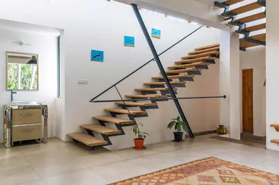 a staircase in a living room with wooden steps at Spacious 3BR Daveys Townhouse with Private Lawn Pet Friendly and Complimentary Breakfast in Mysore