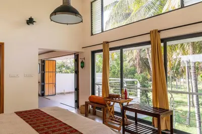 a bedroom with a bed and a large window at Spacious 3BR Daveys Townhouse with Private Lawn Pet Friendly and Complimentary Breakfast in Mysore