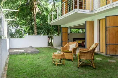 a patio with chairs and a table in the grass at Spacious 3BR Daveys Townhouse with Private Lawn Pet Friendly and Complimentary Breakfast in Mysore