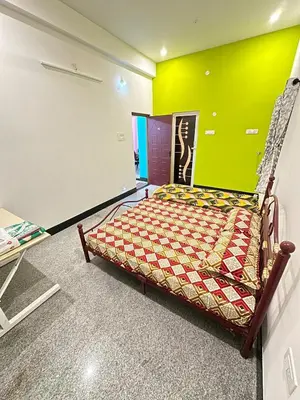 a bed in a room with a green wall at Bhargavi homes in Coimbatore