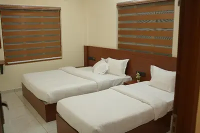 two beds in a hotel room with white sheets at Joen homes apartment in Alwaye