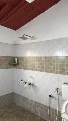 a bathroom with a shower and a toilet and a sink at Cityscape Residence and Homestay Tirupur in Tiruppūr