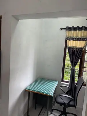 a chair and a table in a room with a window at Midnight Oasis Wayanad in Meenangadi