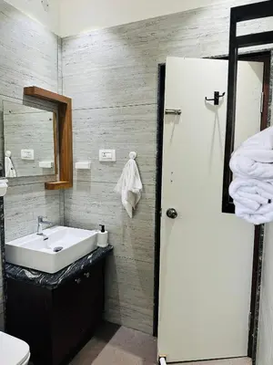 a bathroom with a sink and a mirror at CLR Homestay & Villa in Kushālnagar