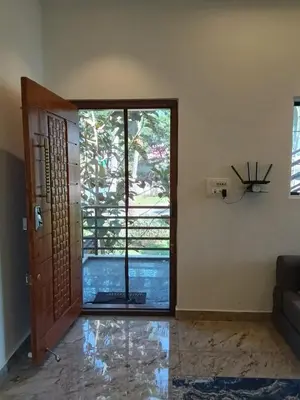 a living room with a door and a window at CLR Homestay & Villa in Kushālnagar