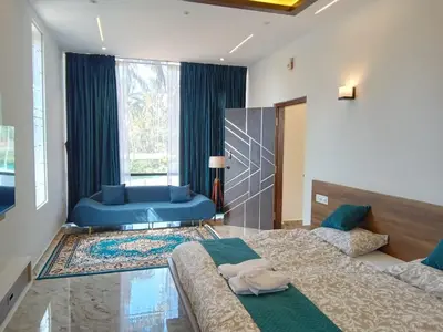 a bedroom with two beds and a blue couch at CLR Homestay & Villa in Kushālnagar