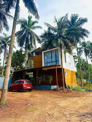 a house with a car parked in front of it at CLR Homestay & Villa in Kushālnagar