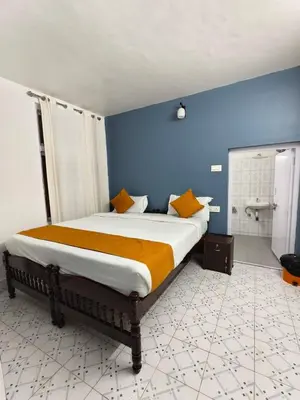 a bedroom with a bed and a blue wall at Kalanja Greens Nilagiri Villa in Ooty