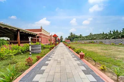 a walkway in a garden in front of a building at Palette Peace Village by CheckIn | Garden | Breakfast | Erode in Erode