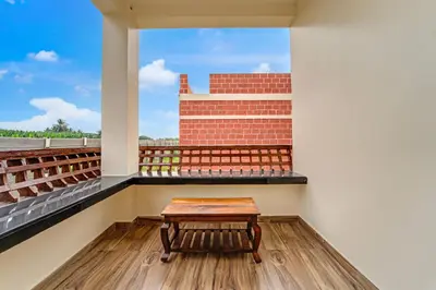 a table on the balcony of a building at Palette Peace Village by CheckIn | Garden | Breakfast | Erode in Erode