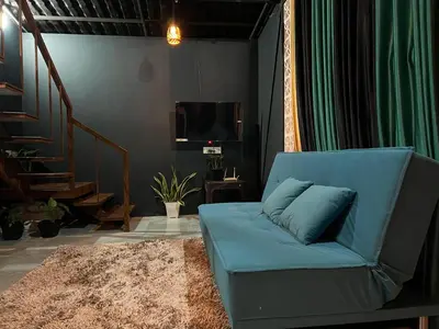 a blue couch in a living room with a television at The Stellar By Stayzi in Nilambūr