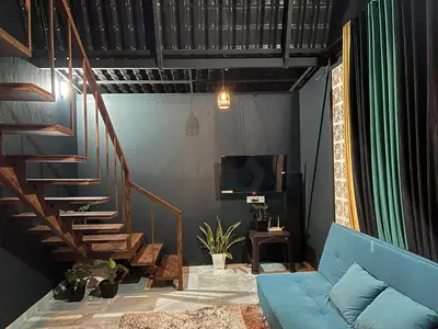 a living room with a blue couch and a staircase at The Stellar By Stayzi in Nilambūr