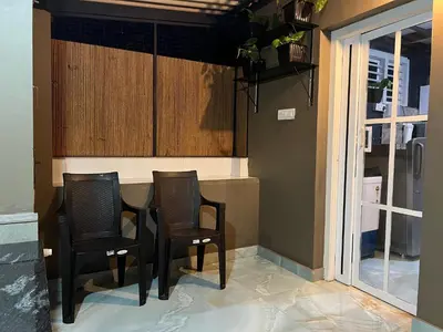 a kitchen with two chairs and a table with a window at The Stellar By Stayzi in Nilambūr