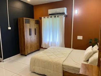 a bedroom with a bed and a window with a air conditioner at The Stellar By Stayzi in Nilambūr