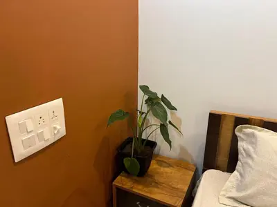 a potted plant on a table next to a bed at The Stellar By Stayzi in Nilambūr