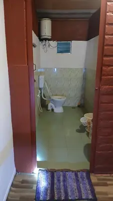 a bathroom with a toilet in a room at BeingWild Resort in Masinagudi
