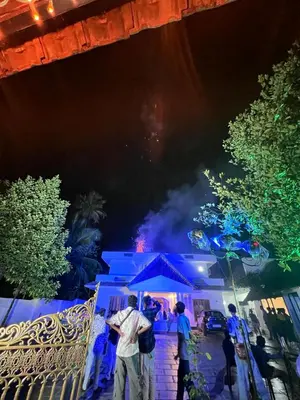 a group of people standing outside a house at night at Haveninn in Athirappilly