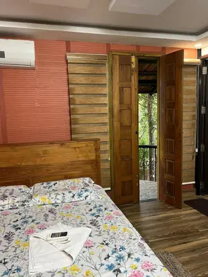 a bedroom with a bed with a pillow on it at Apricot Cottage in Kozhikode