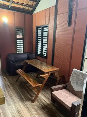 a living room with a table and a couch at Apricot Cottage in Kozhikode