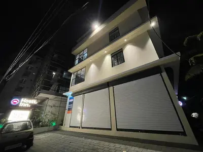 a large white building with a garage door at night at The Marina Deluxe Kozhikode - Premium Spacious AC Rooms in Kozhikode