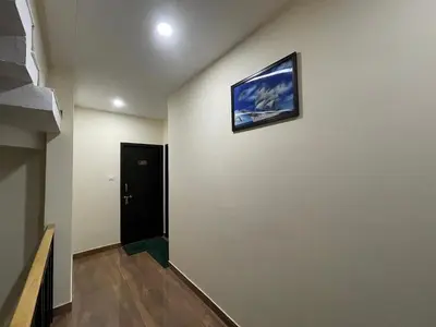 a hallway with a picture hanging on a wall at The Marina Deluxe Kozhikode - Premium Spacious AC Rooms in Kozhikode