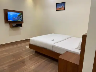 a bedroom with a bed and a flat screen tv at The Marina Deluxe Kozhikode - Premium Spacious AC Rooms in Kozhikode