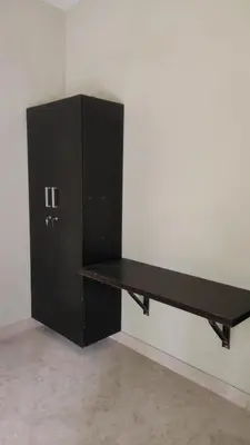 a black desk in the corner of a room at Green Valley stay in Pattāmbi