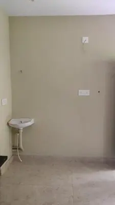 a room with a white wall with a basketball hoop at Green Valley stay in Pattāmbi
