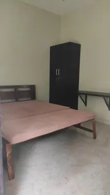 a large wooden bed sitting in a room at Green Valley stay in Pattāmbi