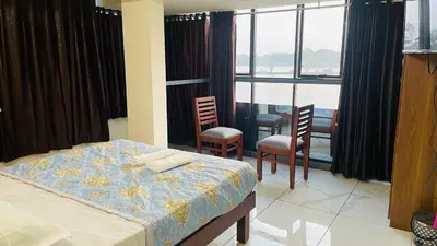 a bedroom with a bed and some chairs and windows at Malayattoor Castle in Kodanad