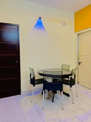 a dining room table with chairs and a blue light at Malayattoor Castle in Kodanad