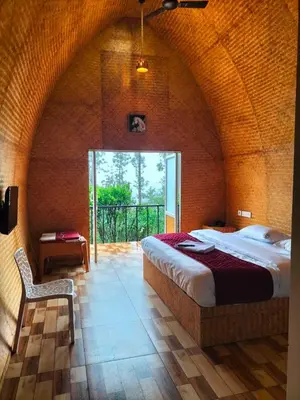 a bedroom with a bed and a chair in a room at Bhramaram resort in Kanthalloor