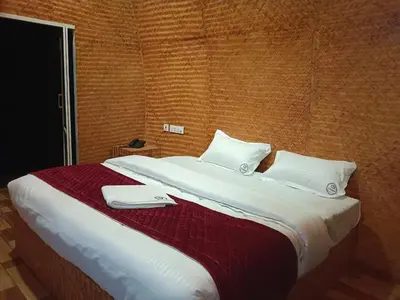 a large bed with two white towels on it at Bhramaram resort in Kanthalloor