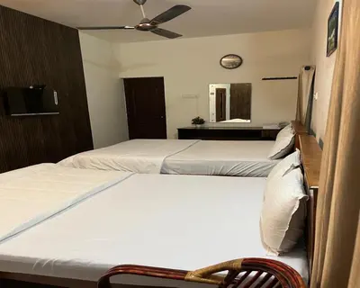 a bedroom with two beds and a ceiling fan at The Whistling Pine Woods in Varagampadi