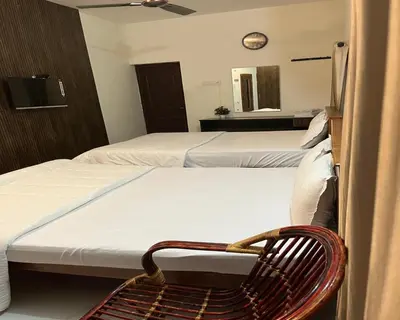 a room with two beds with a chair and a mirror at The Whistling Pine Woods in Varagampadi
