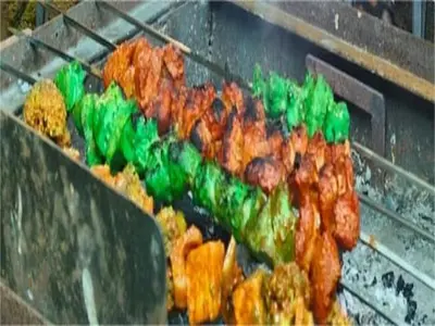 a bunch of meat and other food on a grill at The Whistling Pine Woods in Varagampadi