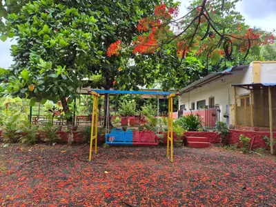 a playground in a yard next to a house at The Whistling Pine Woods in Varagampadi