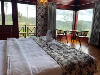 a large bed in a room with a large window at Western Valley Resorts Ooty in Ooty