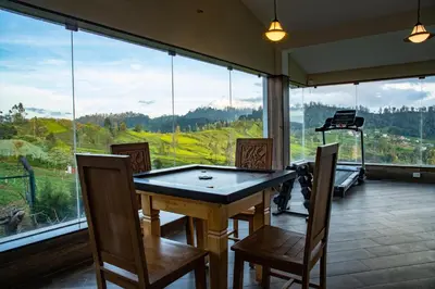 a room with a table and chairs and a large window at Western Valley Resorts Ooty in Ooty