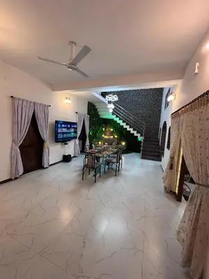 a large living room with a table and a tv at 5 BHK Luxurious & Spacious Villa in Mysuru in Mysore