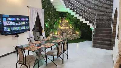 a dining room with a table with chairs and a staircase at 5 BHK Luxurious & Spacious Villa in Mysuru in Mysore