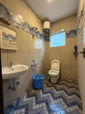 a bathroom with a sink and a toilet at Murthi's Farm House in Coimbatore