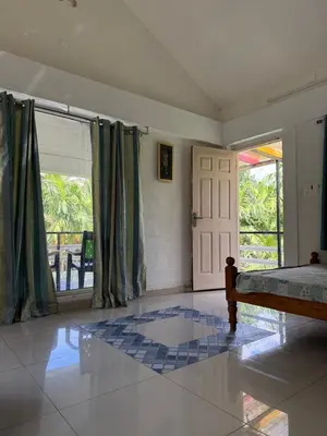 a bedroom with a bed and a window and a door at Murthi's Farm House in Coimbatore