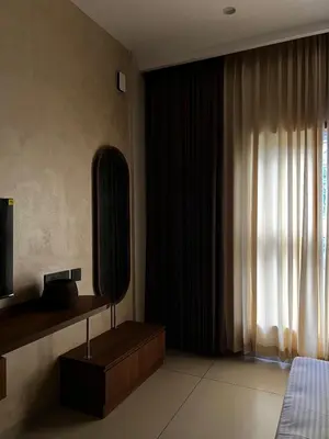 a bedroom with a mirror and a bed and a television at Townsquare Residency in Kommeri