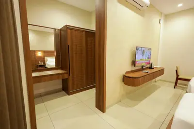 a hotel room with a desk with a computer on it at Townsquare Residency in Kommeri