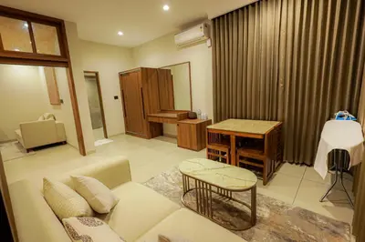 a living room with a couch and a table at Townsquare Residency in Kommeri