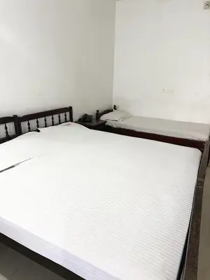 a bed in a room with a white mattress at Sathya Inn Guruvayur in Trichūr