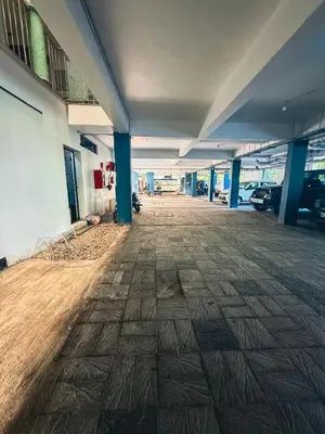 an empty parking garage with blue columns in a building at Sathya Inn Guruvayur in Trichūr