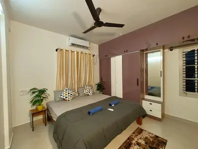 a bedroom with a bed and a ceiling fan at Namasvi 2Bedroom AC House in Narasimharaja Puram