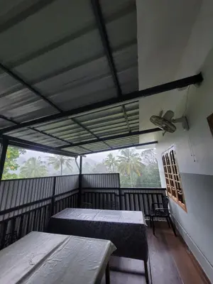 a room with two beds and a large window at Maliyeckal Homes in Viripara
